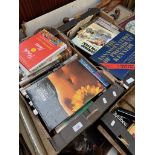 Two boxes of books to include Pirelli calendar book, Compton Mackenzie, Alan Sillitoe, Simenon,