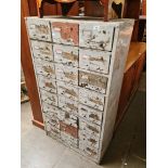 A vintage 24 drawer metal filing cabinet.
