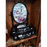 An modern black lacquer and mother of pearl dressing table mirror.