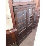 An Ercol dark elm glazed bookcase.