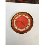 Goldsmiths and Silversmiths Co. brass circular standing small clock with red enamel dial