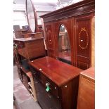 An Edwardian inlaid mahogany bedroom suite comprising a dressing table, a wardrobe and a chest of