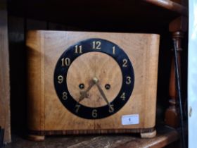 A Walnut Art Deco clock complete with key and pendulum.