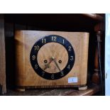 A Walnut Art Deco clock complete with key and pendulum.