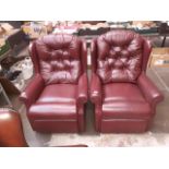 A pair of burgundy leather buttoned back armchairs.