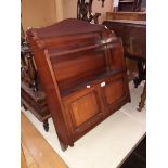 A mahogany wall hanging cabinet with shelves.