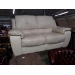 A pair of cream leather 2 seater sofas.