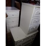 A white chest of drawers, two white bedside cabinets and a light wood effect bedside chest.