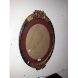 An oval French style picture frame with gilt decoration.
