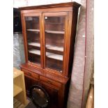 A late Victorian walnut cabinet bookcase together with an oval mirror.