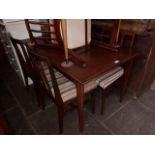 A mid 20th century dining table and four chairs.
