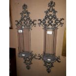 A pair of metal and glass wall hanging candle sconces.