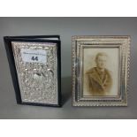 A modern silver photo frame and a silver backed address book.