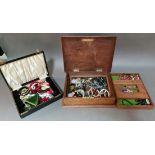 An antique carved wooden box containing costume jewellery and a vintage jewellery box with contents.
