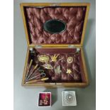 An antique fitted box containing various costume jewellery to include a 9ct gold bracelet / child'