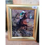 A framed 2021 Grand National winner photograph signed by jockey and trainer.