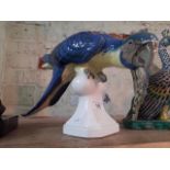 A large Royal Dux porcelain model of a parrot, modelled perched upon a finial, underglaze