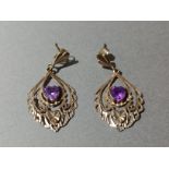 A pair of gold amethyst earrings.
