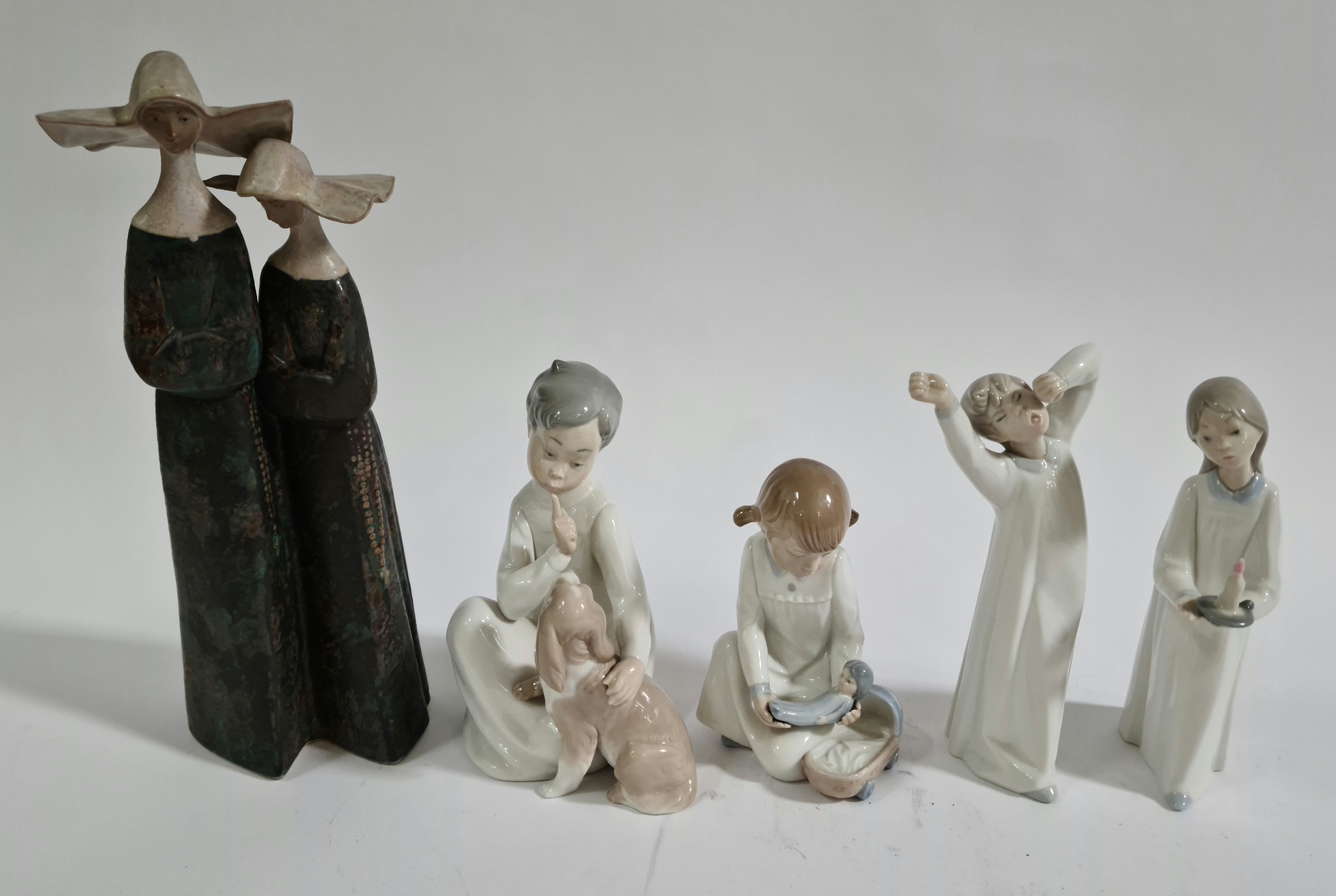 A collection of four Lladro figures and one Nao figure