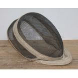 An early 20th century fencing mask, labelled Leon Paul, London.