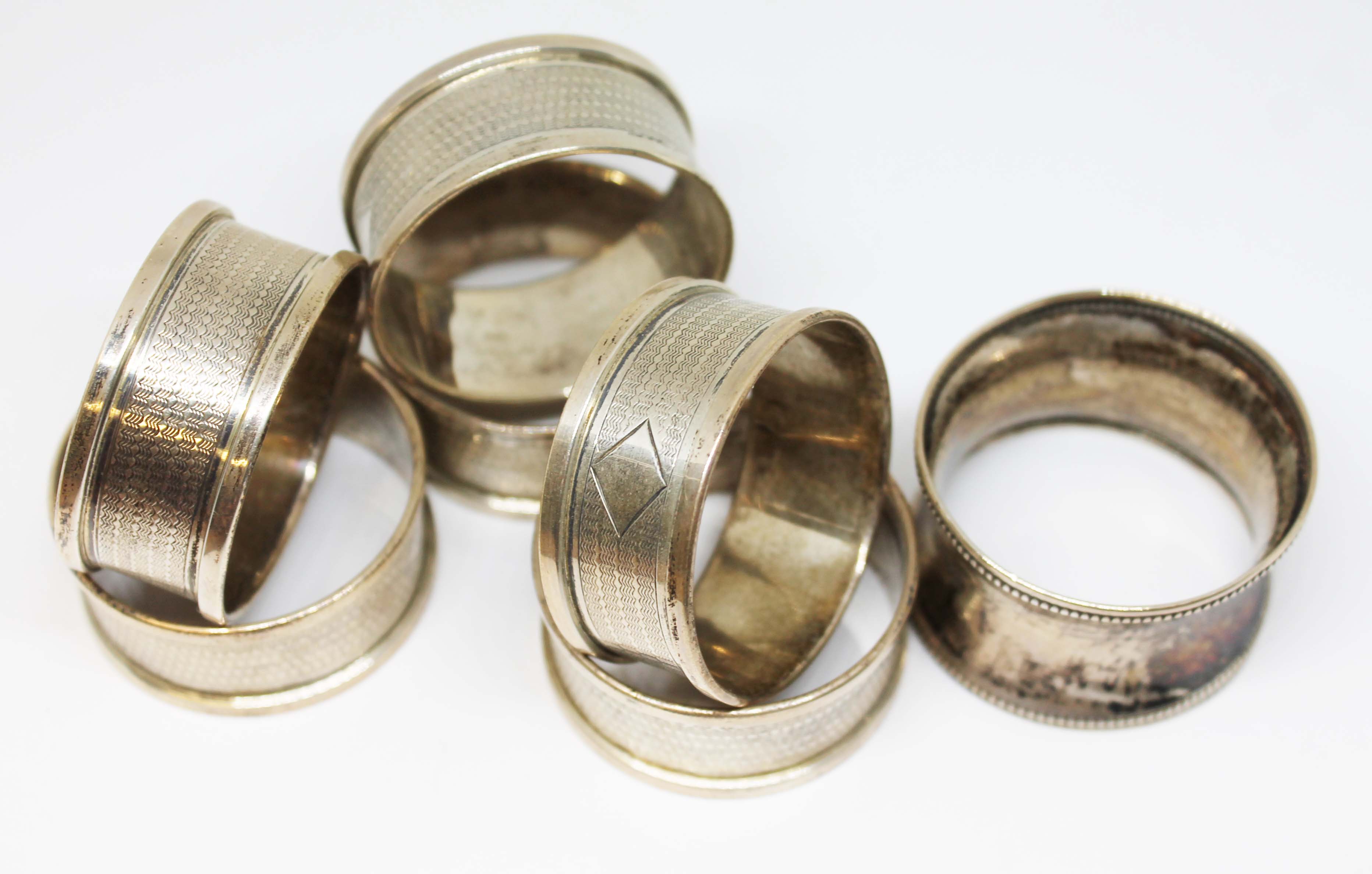 A set of six hallmarked silver serviette rings and another, wt. 83.5g.
