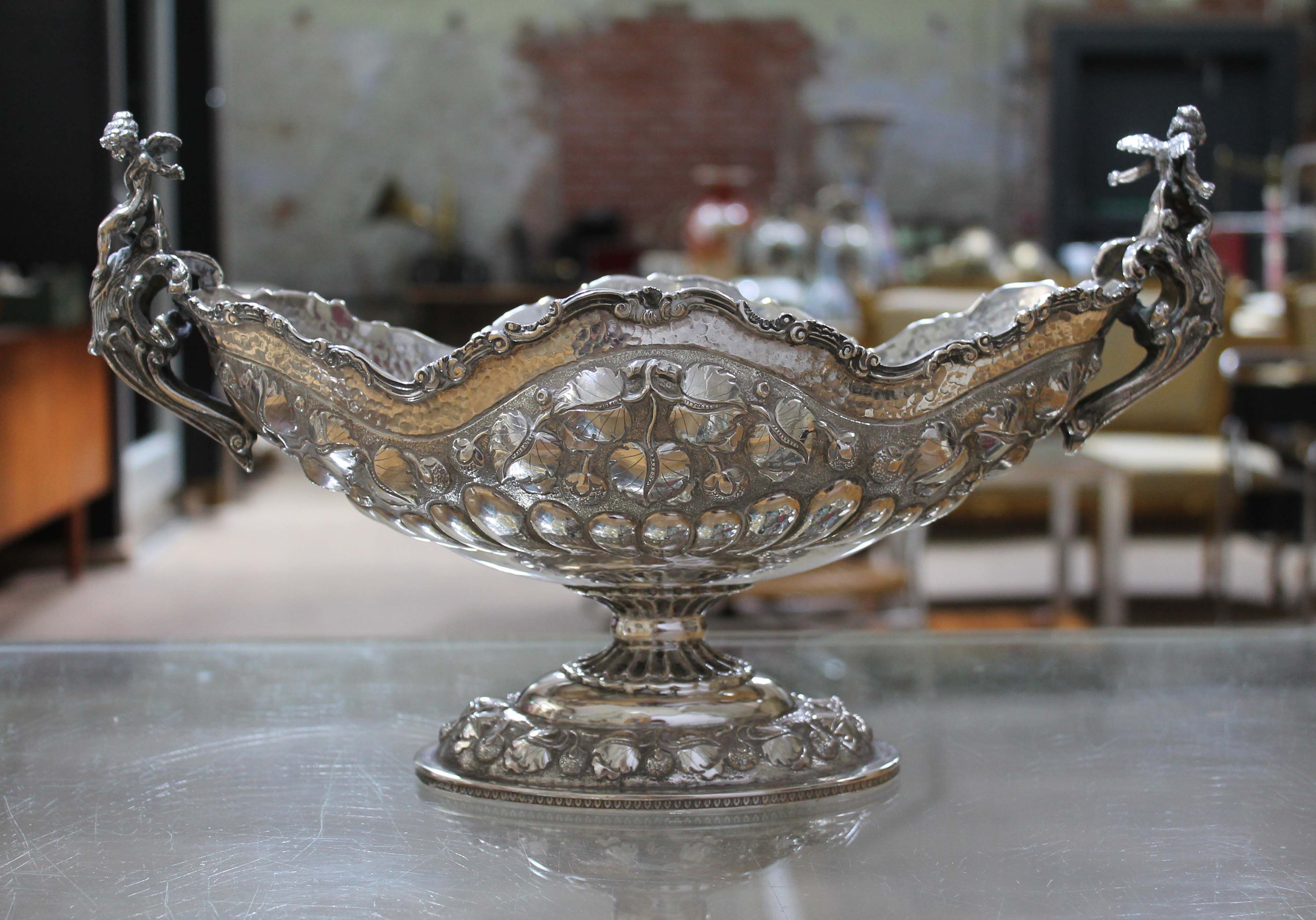 A Greek twin handled silver bowl, decorated with vines, gadrooned and hammered, cast