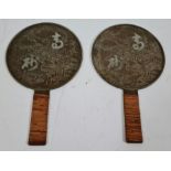 A pair of Chinese bronze hand mirrors.