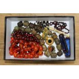 A box of assorted jewellery including hard stone beads carved with faces, cherry bakelite beads, two