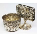 A hallmarked silver repoussé cup and a menu holder, unmarked and as found, gross wt. 134g.