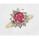 A ruby and diamond cluster ring, the oval cushion cut ruby weighing approx. 0.79ct, surround by