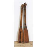 A pair of 'Folk Art' miniature carved wood paddles, the finials carved with a person's face and