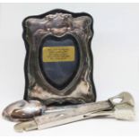 Hallmarked silver comprising a photograph frame, a teaspoon and a cigar cutter.