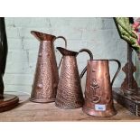 Three Arts & Crafts copper jugs, one by Joseph Sankey & Son.