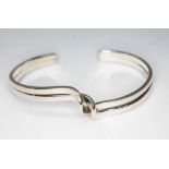 A modernist style bangle, marked '925', wt. 21.96g.
