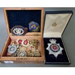An inlaid box with various militry & police badges/buttons etc.