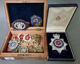 An inlaid box with various militry & police badges/buttons etc.