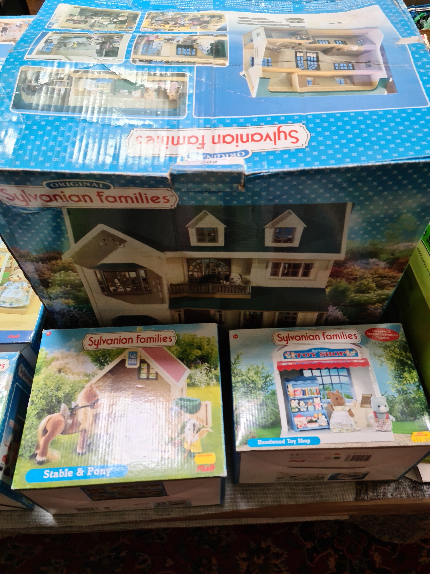 Boxed Sylvanian families toy sets; House on the Hill, Stable & Pony, and Hazelwood Toy Shop.