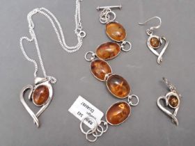 A trio of silver and amber jewellery pieces to include chain with pendant, bracelet and pair of