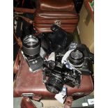 A box of cameras comprising a Pentax K1000, a Praktica VF and a Praktica BC1.