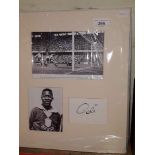 A framed Pele signature with photographic prints.