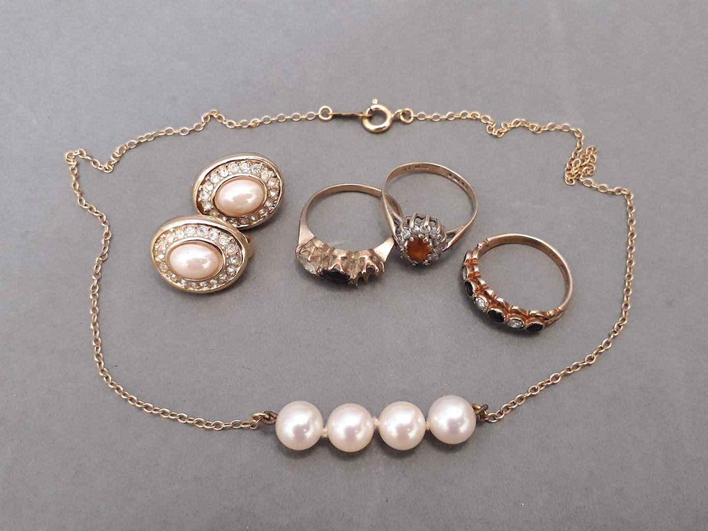 A mixed lot of gold jewellery pieces to include three 9ct gold rings, a cultured pearl necklace