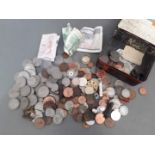 A tin of assorted coins and notes.