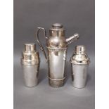 A group of three silver plated cocktail shakers.