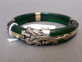 An imitation jade bangle with metal dragon mounts.