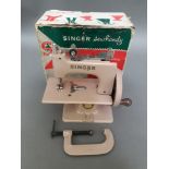 A child's Singer sewing machine, boxed with accessories.