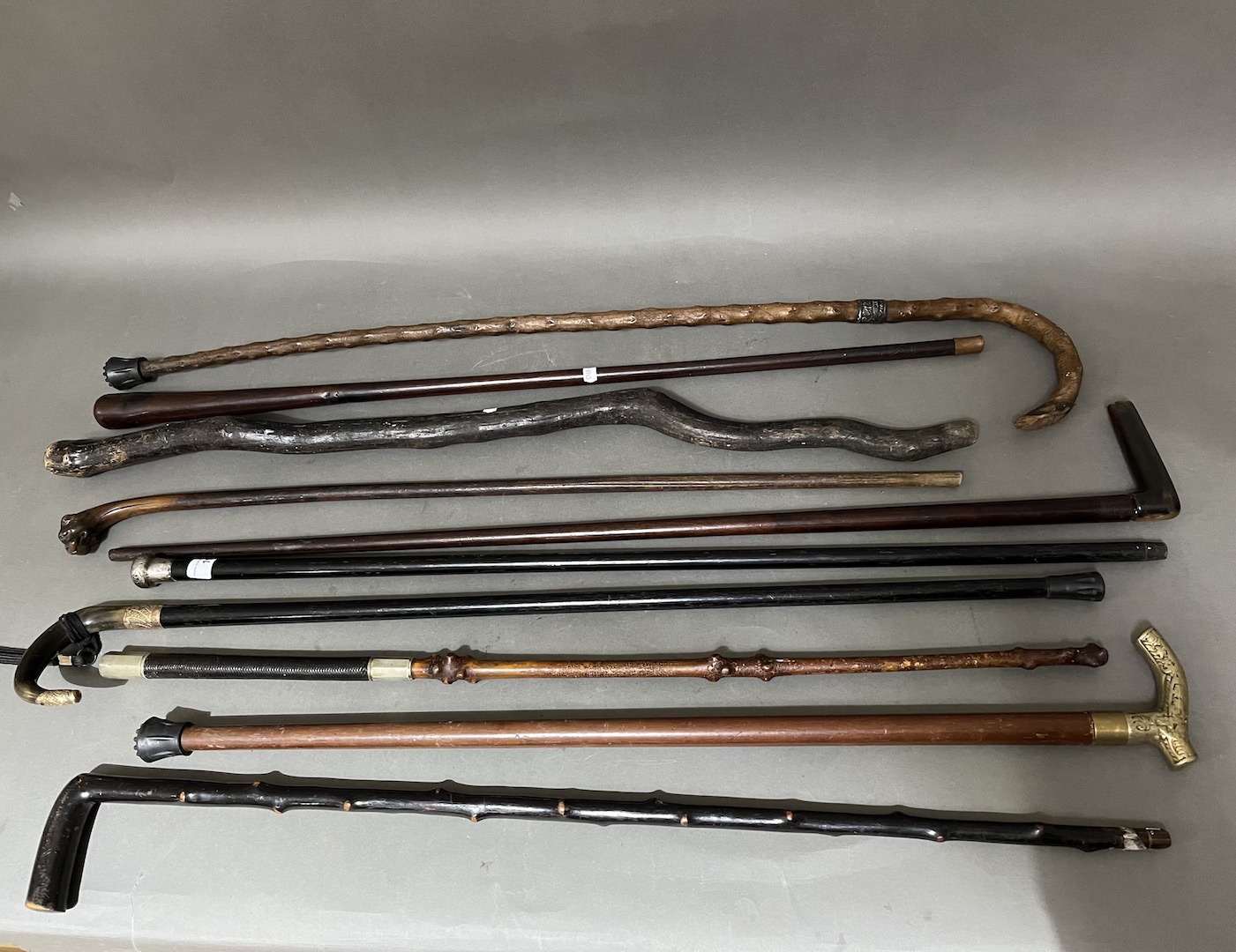 A bundle of walking sticks including silver mounted, horn, gold plated etc.