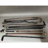 A bundle of walking sticks including silver mounted, horn, gold plated etc.