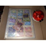 A box containing two binders of vintage 1990s Pokemon cards together with a vintage Pokemon marble