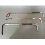 A group of three vintage riding crops.