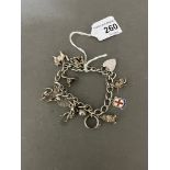 A silver charm bracelet with various novelty charms to include cherub, cat, Aladdin, London